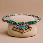 Handmade in Nepal by skilled artisans, this Inlaid Stone Pendant Necklace features a harmonious blend of Turquoise, Lapis Lazuli, and Coral, embodying healing and spiritual renewal for your journey.