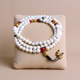 This handmade Japa Mala from Nepal features calming Howlite stones, a Buddha head, and an elephant spacer, serving as a meaningful tool for meditation and spiritual connection.