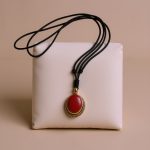 The Coral Stone Pendant Necklace, handcrafted in Nepal by skilled artisans, serves as a protective talisman, embodying compassion and harmony while promoting inner peace and well-being.