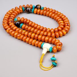 Handmade in Nepal, this Orange Resin Ambar Prayer Mala with Tiger Eye spacer is a spiritual tool that invites peace and transformation into your meditation practice.