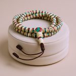 Handmade in Nepal by skilled artisans, this Inlaid Yak Bone Japa Mala serves as a spiritual companion, fostering focus and resilience on your journey towards personal growth and enlightenment.