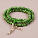 Handmade in Nepal by skilled artisans, this Green Inlaid Yak Bone Prayer Mala embodies the blessings of Green Tara and Amoghasiddhi, fostering spiritual connection and resilience in practice.