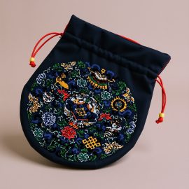 Handmade in Nepal by skilled artisans, this Blue Eight Auspicious Symbol Embroidered Mala Bag is a sacred vessel for your mala beads, embodying spiritual protection and abundance.