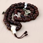 Handmade in Nepal by skilled artisans, this Bodhi seed yoga mala features one-eye markings and howlite spacers, serving as a tool for mindfulness and spiritual clarity.