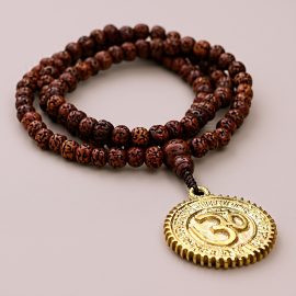 Handmade in Nepal by skilled artisans, this Dark Brown Hindu Om Rudraksha Bead Japa Mala serves as a sacred companion for meditation, fostering spiritual connection and grounding energy.