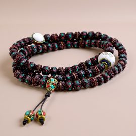 Handmade in Nepal by skilled artisans, this dark maroon rudraksha seed mala with a conch shell symbolizes spiritual awakening and protection, guiding practitioners on their journey towards inner peace.