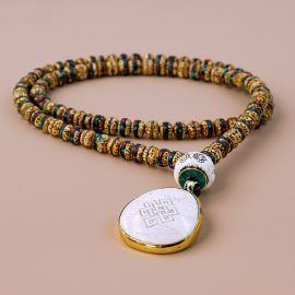 Handmade in Nepal by skilled artisans, this mala features lotus seeds and a conch shell, symbolizing purity, spiritual growth, and harmony in your meditation practice.