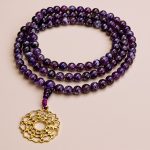 Handmade in Nepal by skilled artisans, this Amethyst Stone Japa Mala with a Crown Chakra pendant aids meditation, fostering tranquility and enhancing your spiritual journey towards enlightenment.