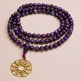 Handmade in Nepal by skilled artisans, this Amethyst Stone Japa Mala with a Crown Chakra pendant aids meditation, fostering tranquility and enhancing your spiritual journey towards enlightenment.