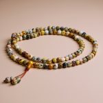 Handmade in Nepal by skilled artisans, this Japa Mala features nurturing Australian Butter Jasper Stone, promoting emotional balance and inner peace for focused meditation and spiritual growth.
