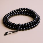 Handmade in Nepal by skilled artisans, this Black Onyx Stone Japa Mala aids in grounding and protection, enhancing concentration during meditation and mantra chanting.