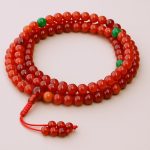 Handmade in Nepal by skilled artisans, this carnelian stone mala with jade spacers promotes stability, grounding, and creativity, supporting your spiritual journey and enhancing overall well-being.
