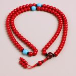 Handmade in Nepal by skilled artisans, this Coral Stone Prayer Mala features vibrant coral beads and turquoise spacers, promoting emotional balance and spiritual purification during your practice.
