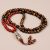 Handmade in Nepal by skilled artisans, this 3 Eye Dzi Tiger Eye Prayer Mala with Carnelian Stone fosters spiritual balance and protection, serving as a sacred tool for your journey.