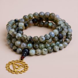 Handmade in Nepal by skilled artisans, this Labradorite Japa Mala with Throat Chakra pendant supports spiritual growth and clear communication, fostering harmony and protection on your journey.