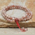 Matte Sun Stone Japa Mala, handmade in Nepal by skilled artisans, supports spiritual practice, fostering inner happiness and courage while promoting a deep connection during meditation and prayer.