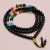 Handmade in Nepal by skilled artisans, this mala features seven chakra beads of matte onyx stone, fostering grounding energy and supporting your spiritual journey through meditation.