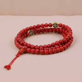 Handmade in Nepal by skilled artisans, this mala features vibrant Synthetic Red Howlite stones and a Double Dorjee, serving as a powerful tool for meditation and emotional healing.