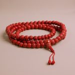 This handmade mala, crafted in Nepal by skilled artisans, features Synthetic Red Howlite, promoting serenity and focus, while aiding in emotional healing and self-expression during meditation.