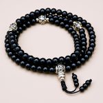 Handmade in Nepal by skilled artisans, this Black Onyx Stone Prayer Mala features 108 beads, supporting your meditation and mantra recitation on the path to spiritual awakening.