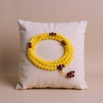 The Yellow Honey Calcite Stone Mala, with Carnelian spacers, is handmade in Nepal by skilled artisans. It supports spiritual growth and self-discovery through meditation and intention.
