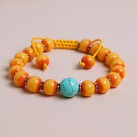 Handmade in Nepal by skilled artisans, this Resin Ambar Wrist Mala features turquoise spacers, promoting healing, emotional balance, and spiritual growth through its connection to ancestral wisdom.