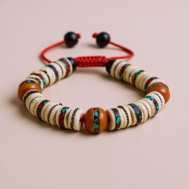 The Inlaid Yak Bone Wrist Mala, handmade in Nepal by skilled artisans, symbolizes the teachings of impermanence, serving as a powerful tool for meditation and mindfulness.