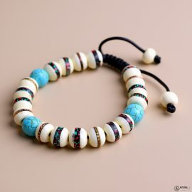 This handmade wrist mala from Nepal, crafted by skilled artisans, features yak bone and turquoise, serving as a reminder of impermanence while fostering compassion and emotional harmony.