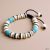 This handmade wrist mala from Nepal, crafted by skilled artisans, features yak bone and turquoise, serving as a reminder of impermanence while fostering compassion and emotional harmony.