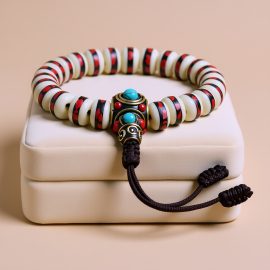 This handmade wrist mala, crafted in Nepal from yak bone and adorned with a brass bead, embodies wisdom and purity, enhancing one's spiritual journey through meditation and mindfulness.