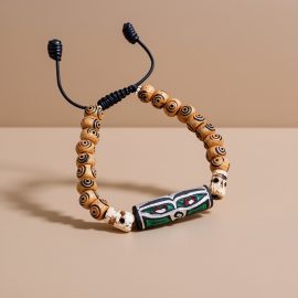 Handmade in Nepal by skilled artisans, this yak bone wrist mala features the Wisdom Buddha Eye and mantra carvings, serving as a meaningful aid for meditation and mindfulness.