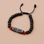 Handmade in Nepal by skilled artisans, this yak bone wrist mala features the Wisdom Buddha Eye, symbolizing spiritual awareness and the impermanence of worries, while coral stones enhance vitality.