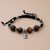 The Black Buddha Hand Knotted Tiger Eye Stone Wrist Mala, handmade in Nepal by skilled artisans, embodies grounding energy, promoting protection and healing while inviting positivity into your daily life.