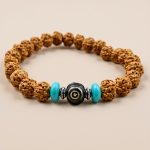 Five Faces Rudraksha wrist mala, handcrafted in Nepal, connects you to the elements and Lord Jupiter, offering wisdom and protection while inspiring compassion through Yak Bone's symbolism of impermanence.