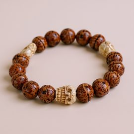 Handcrafted in Nepal by skilled artisans, this Bodhi wrist mala features sacred Phoenix Eye seeds and Yak bone skull beads, serving as a reminder of impermanence and a companion for meditation.