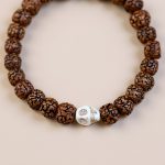 Handmade in Nepal by skilled artisans, this wrist mala with Rudraksha seeds and skull beads serves as a sacred tool for meditation, fostering mindfulness and spiritual growth.