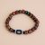 This handmade Dzi Bead Inlaid Rudraksha Seed Wrist Mala from Nepal serves as a spiritual companion, promoting meditation, protection, and harmony in daily life.