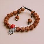 The Hamsa hand, handmade in Nepal by skilled artisans, symbolizes the victory of good over evil, enhancing rudraksha wrist malas to invite positivity and divine grace into your life.