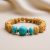 Handmade in Nepal by skilled artisans, this wrist mala features five-faced Rudraksha beads and Turquoise stones, supporting spiritual growth and harmony in one's life.