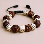 This handmade wrist mala from Nepal combines sacred Three Eye Yak Bone and Indian Bodhi seeds, guiding your meditation and offering protection on your spiritual path.