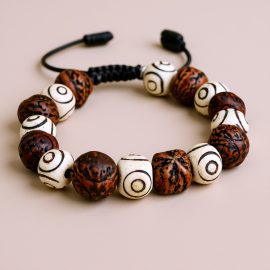 This handmade wrist mala from Nepal combines sacred Three Eye Yak Bone and Indian Bodhi seeds, guiding your meditation and offering protection on your spiritual path.