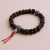 The Dark Rudraksha Seed Wrist Mala, handmade in Nepal by skilled artisans, promotes inner peace and spiritual awakening, connecting you to the protective essence of sacred traditions.