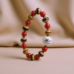 Handmade in Nepal by skilled artisans, this wrist mala features 10 mm lotus seeds and 8 mm coral stones, symbolizing purity and courage for your spiritual journey.