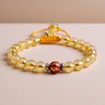 Handmade in Nepal by skilled artisans, this wrist mala features Citrine and mantra-carved Carnelian stones, promoting abundance, vitality, and emotional balance for your meditation practice.