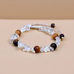 Handmade in Nepal by skilled artisans, this wrist mala combines clear quartz and tiger eye, fostering clarity, confidence, and a deeper connection to your spiritual journey.