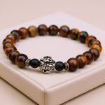 Dependence Tiger Eye Stone Wrist Mala, handmade in Nepal by skilled artisans, harnesses the protective energy of tiger eye, fostering confidence and emotional balance on your spiritual journey.
