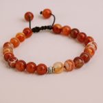 Handmade in Nepal by skilled artisans, this wrist mala features vibrant fire agate beads, fostering emotional balance and grounding during meditation and daily life.