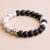 Handcrafted in Nepal by skilled artisans, this wrist mala features calming howlite and grounding lava stone, promoting serenity and emotional balance for your meditation practice.