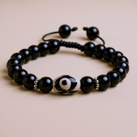 The Tibetan Dzi Black Onyx Stone Wrist Mala, handmade in Nepal, serves as a sacred tool for meditation, promoting grounding and emotional stability through its powerful energy.