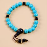 Handmade in Nepal by skilled artisans, this wrist mala features turquoise stones for communication and emotional balance, complemented by matte onyx spacers for grounding during meditation.